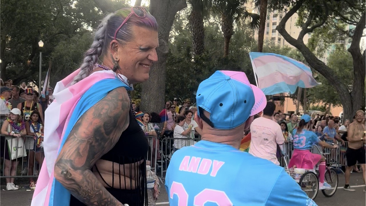 Community members marching with transgender and LGBTQIA+ flags at the 2024 St. Pete Pride Trans Pride March