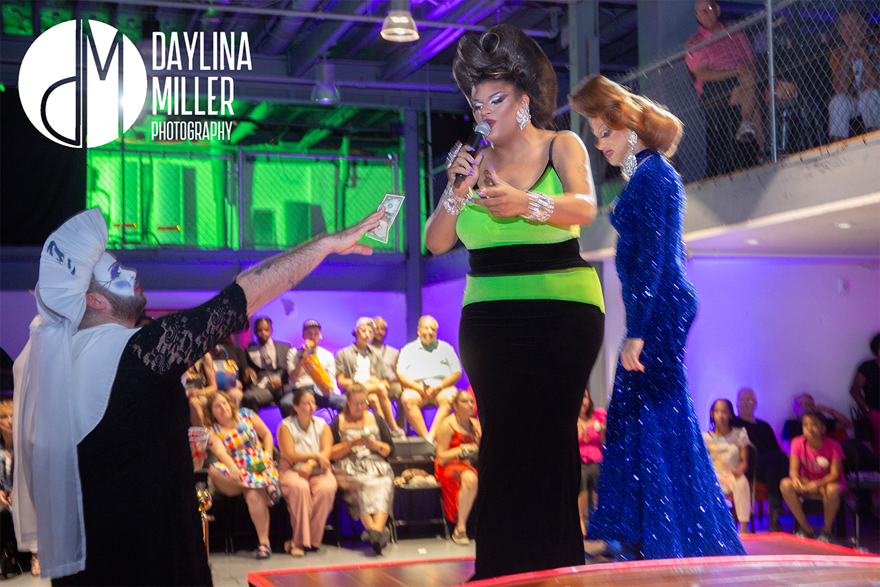 A Sister of Perpetual Indulgence tipping a drag performer on stage at the UNI-Tea Dance.