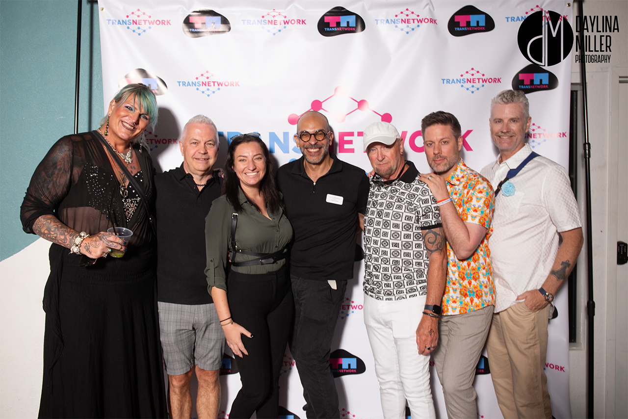 Group of TransNetwork team members, including leaders Devika (left) and Andre (center with glasses), posing with friends at the UNI-Tea Dance.